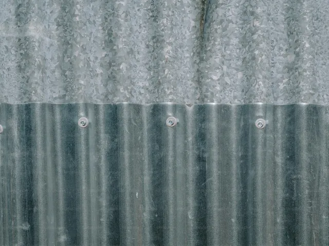 A corrugated metal garage wall, the kind of uninsulated skin that tracks the outside temperature