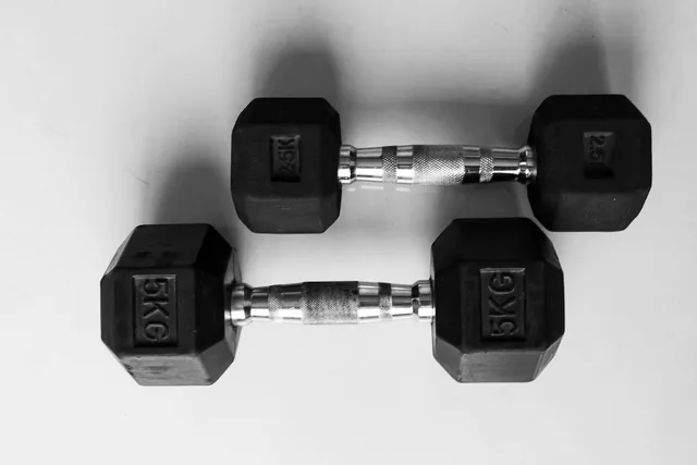 Two fixed hex dumbbells lying side by side, each stamped with its weight