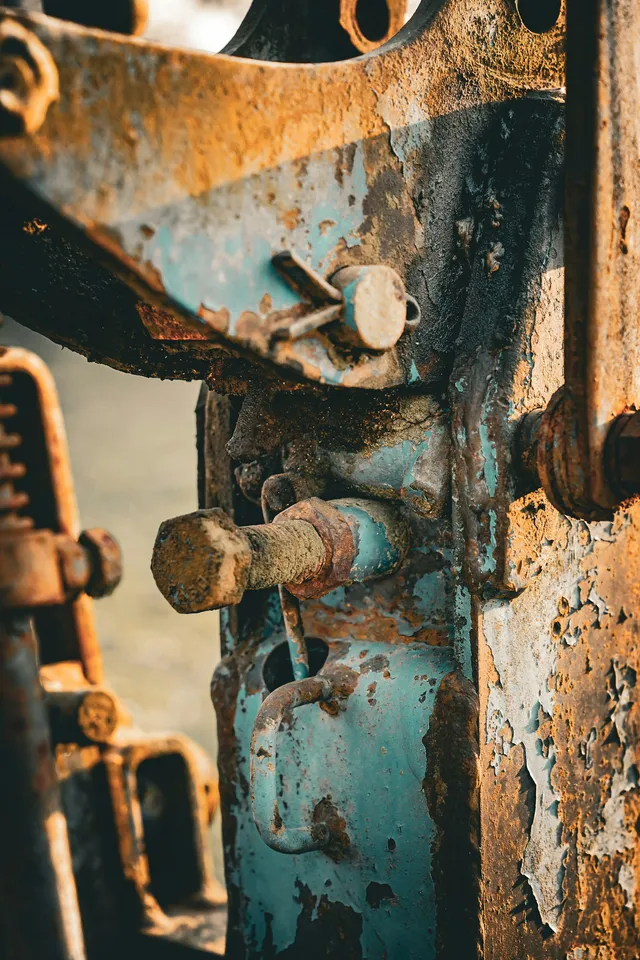 Close-up of weathered industrial machinery, bolts and brackets rusted at the joints