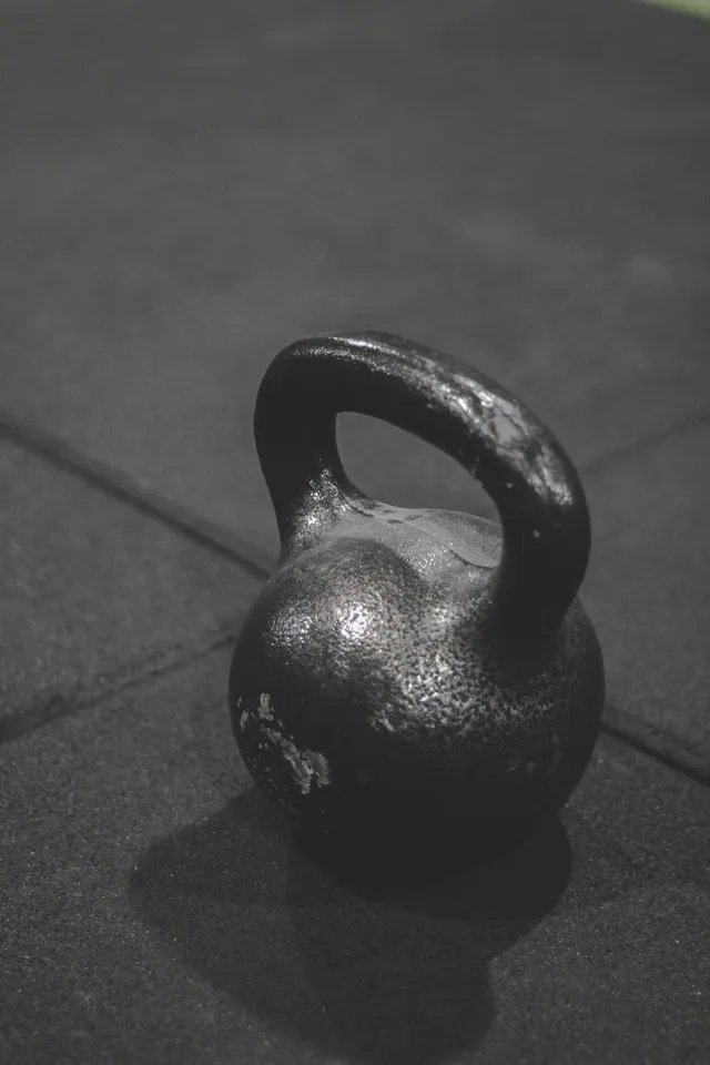 A single kettlebell sitting alone on a hard floor, at exactly the height a small child moves through