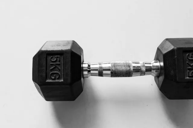 A single hex dumbbell marked 5 KG photographed alone on a plain white surface